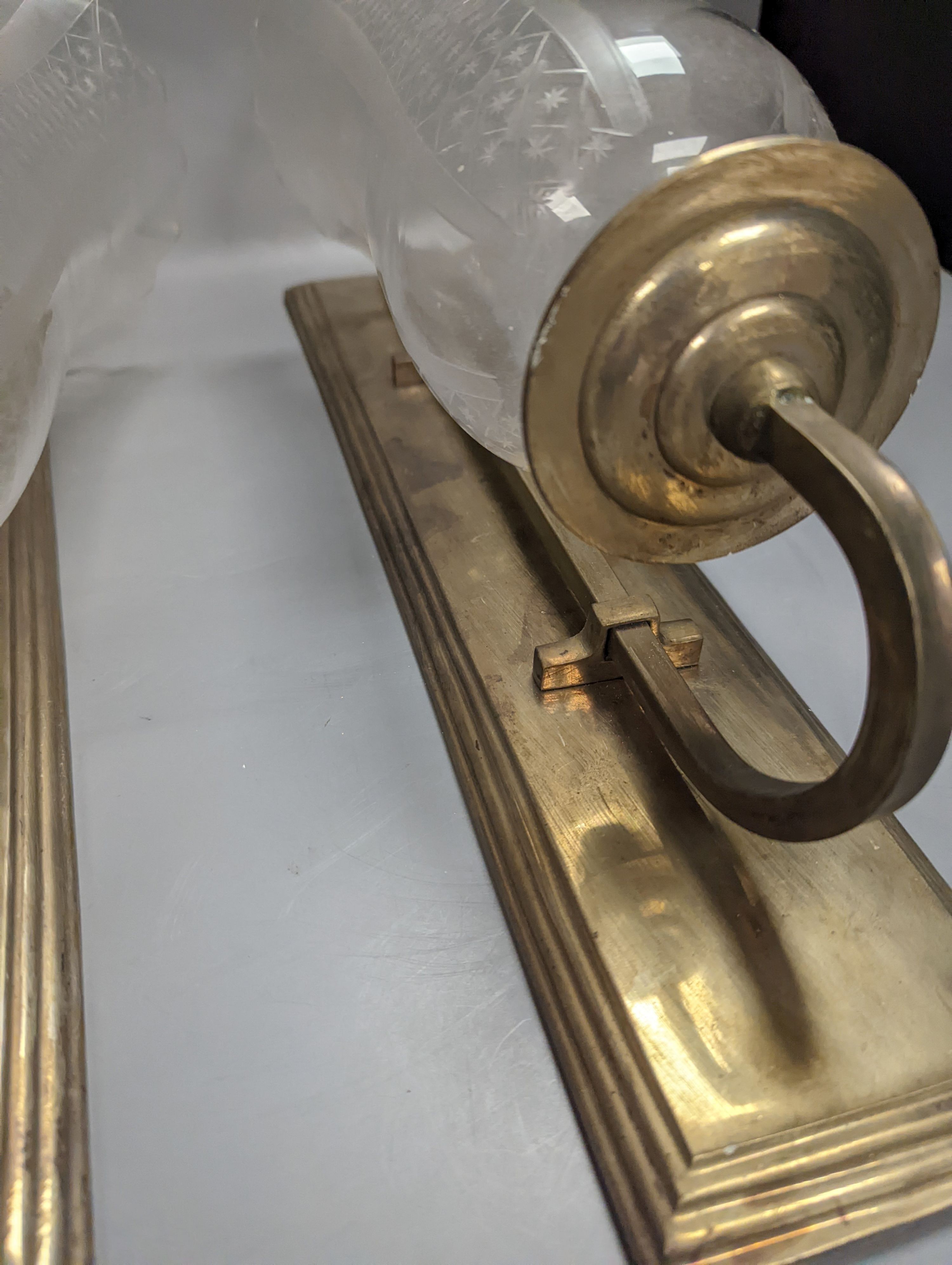 A pair of brass wall lights, with engraved glass storm shades, height 44cm